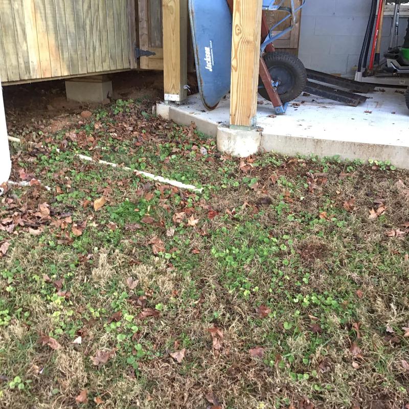 PVC drainage pipe beside wooden deck and concrete slab