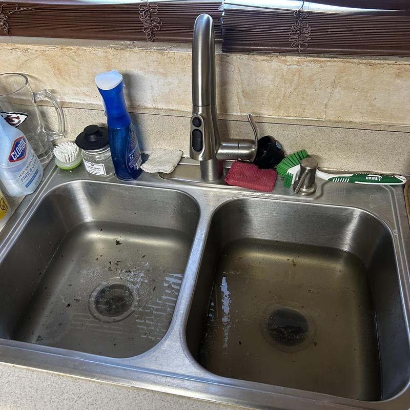 Kitchen sink drain with debris before cleaning