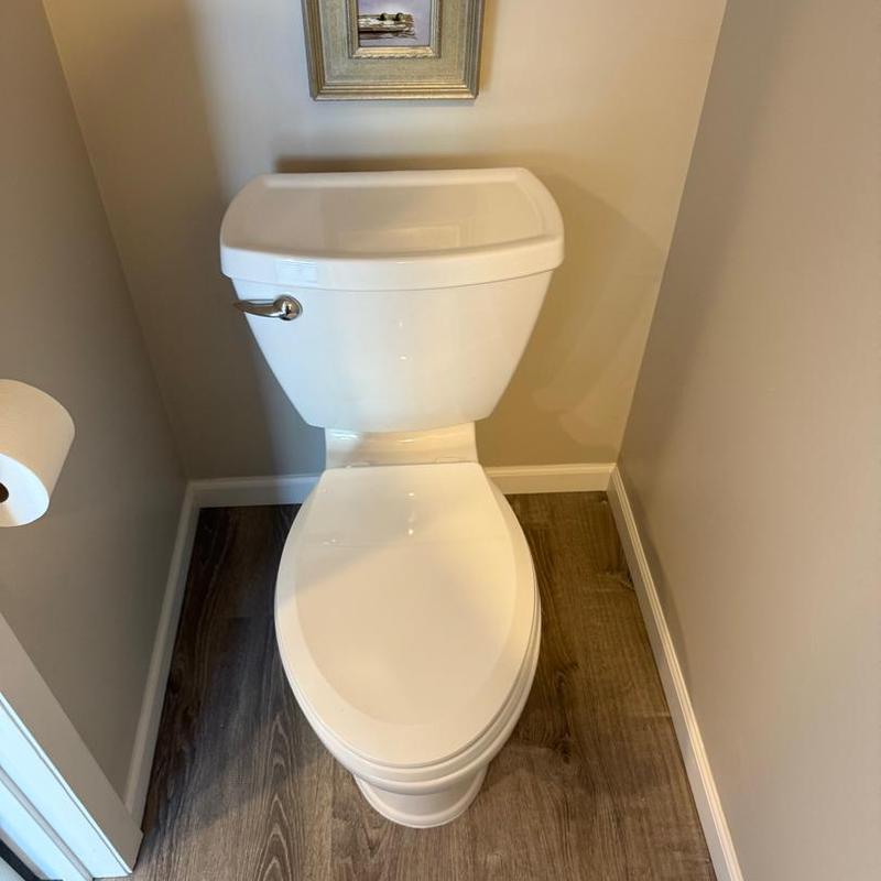 Toilet with tank in small bathroom corner