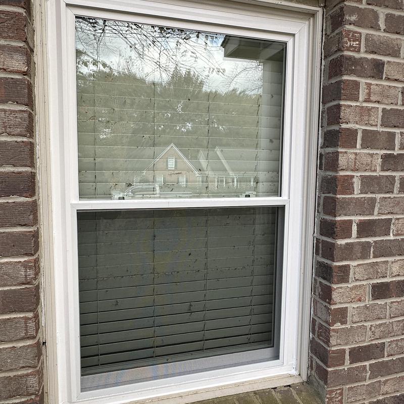 Double-hung insulated white window installed in brick wall Double-hung insulated white window installed in brick wall