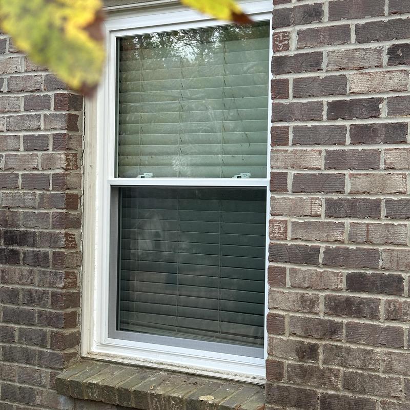 Double hung insulated white window installation on brick wall Double hung insulated white window installation on brick wall