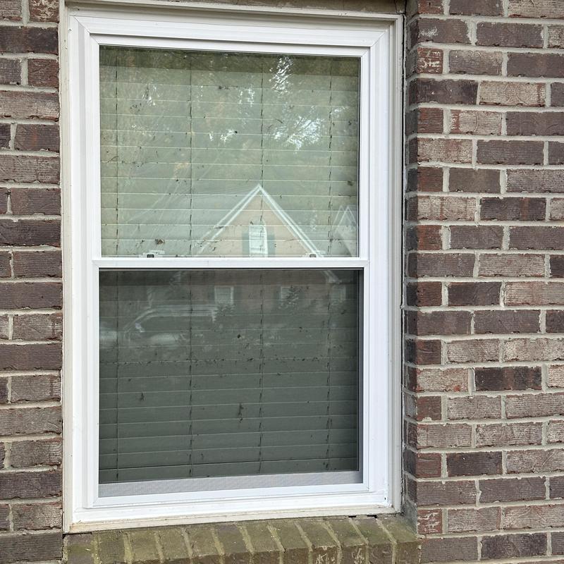 Double hung white insulated window installed in brick wall Double hung white insulated window installed in brick wall