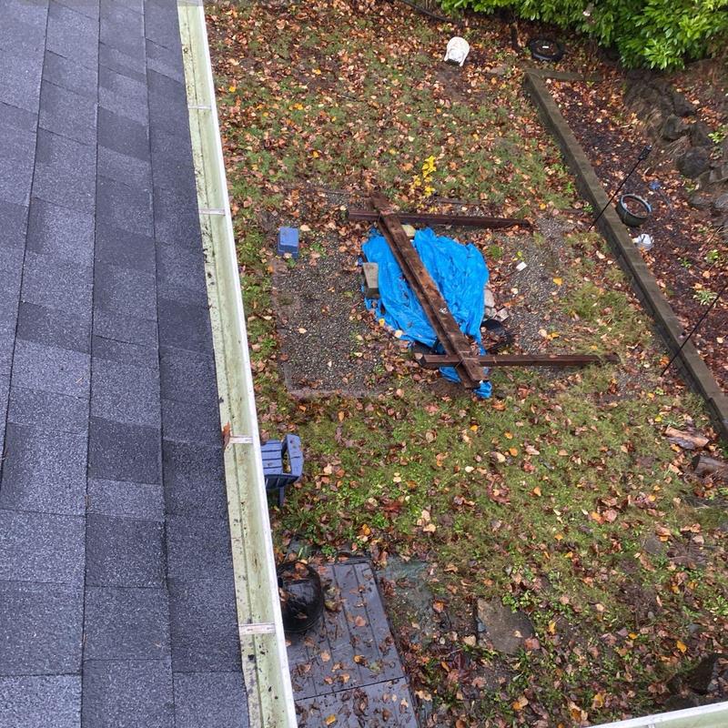 Gutter filled with leaves before cleaning on roof edge