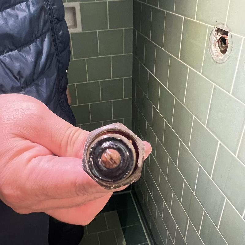Shower stem with worn washer held for repair