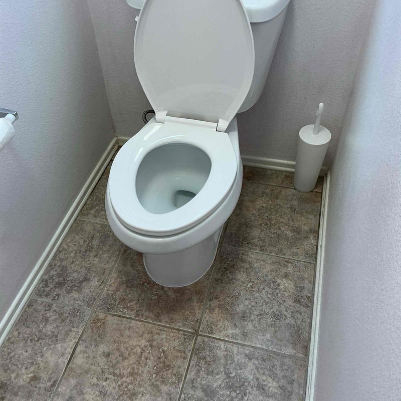 Elongated chair height toilet installation in bathroom