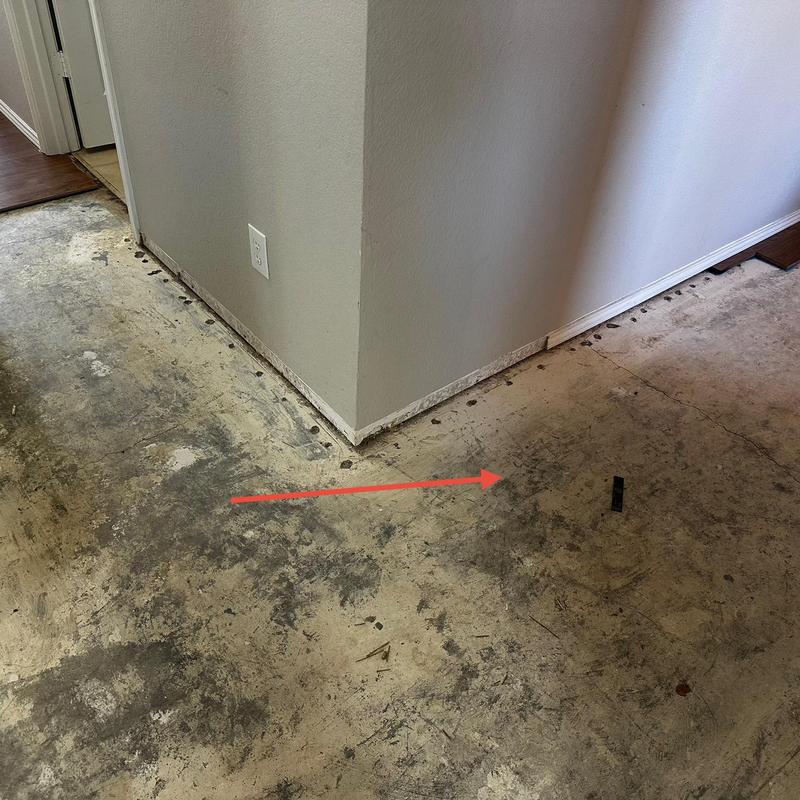 Slab leak location marked with red arrow under concrete