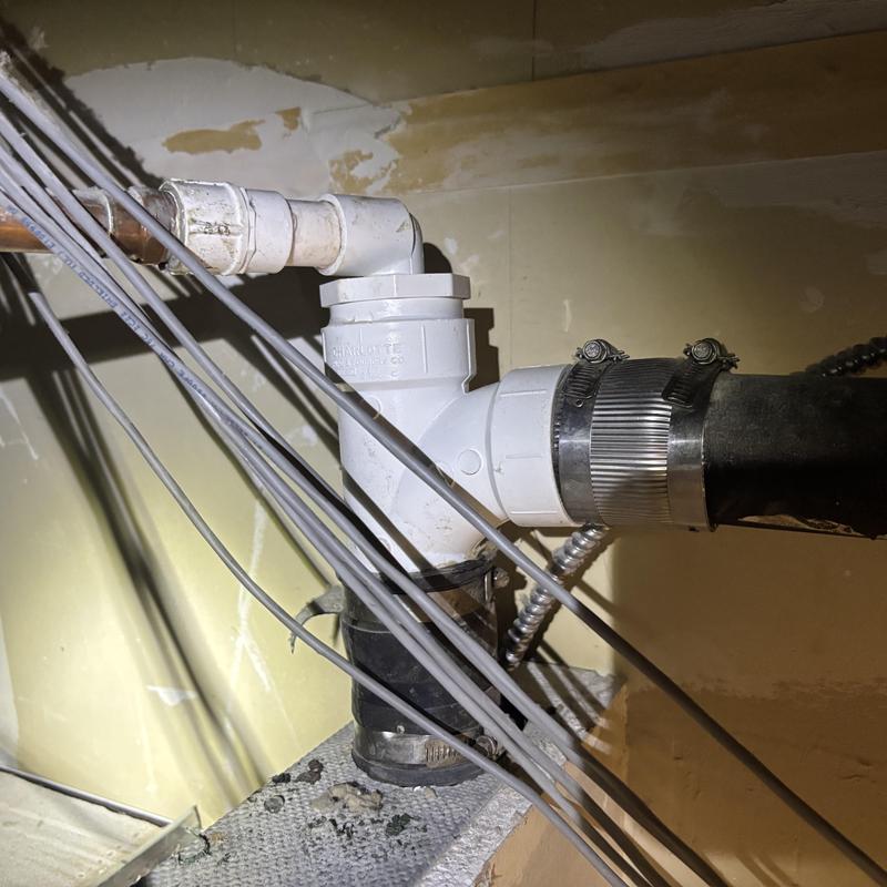 Vent stack pipe with clamps and wiring nearby