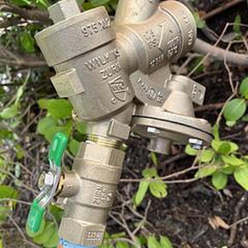 Backflow prevention device installed outdoors with valve