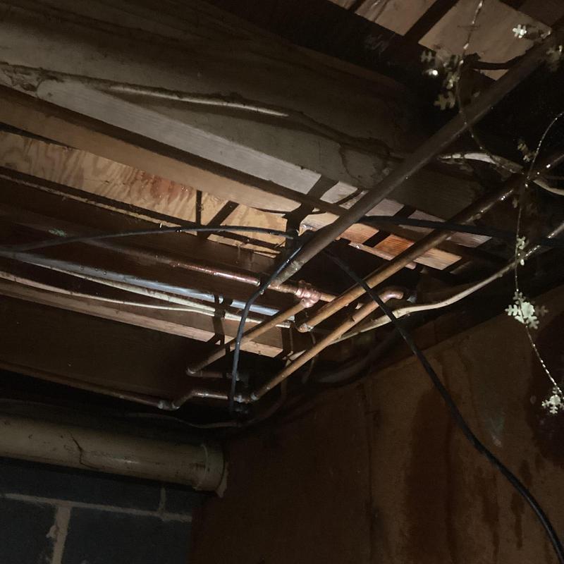 Copper plumbing pipes under ceiling with water leak inspection