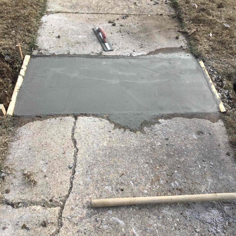 Concrete sidewalk patch with finishing tools