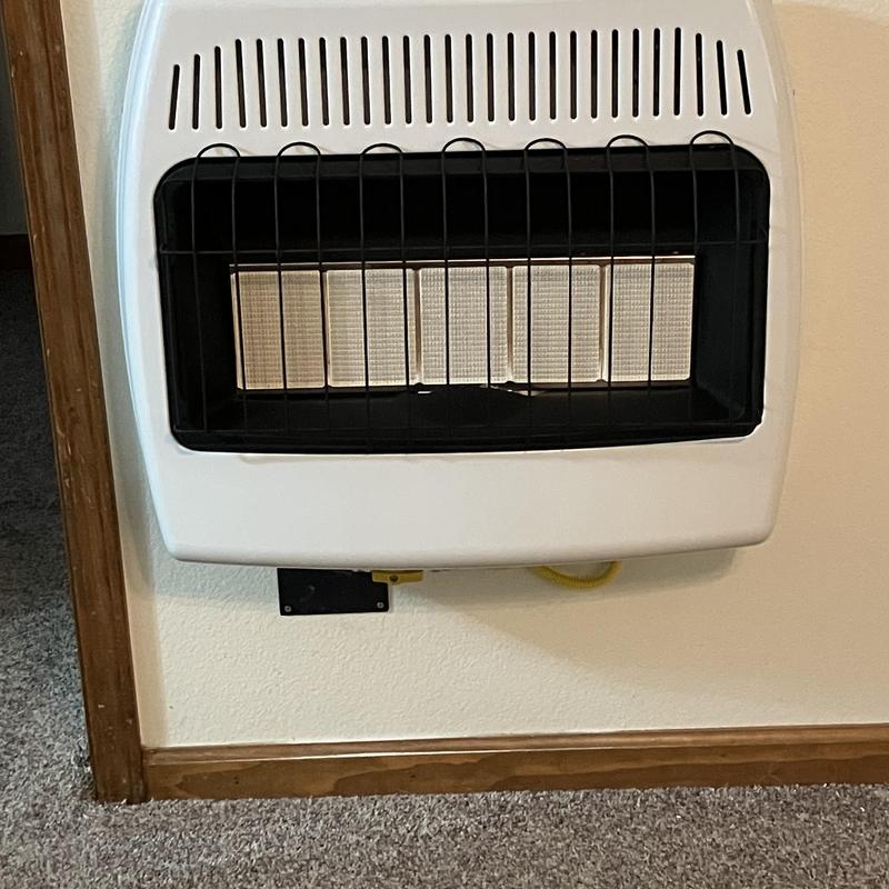 Wall-mounted gas heater with safety grill and pipe
