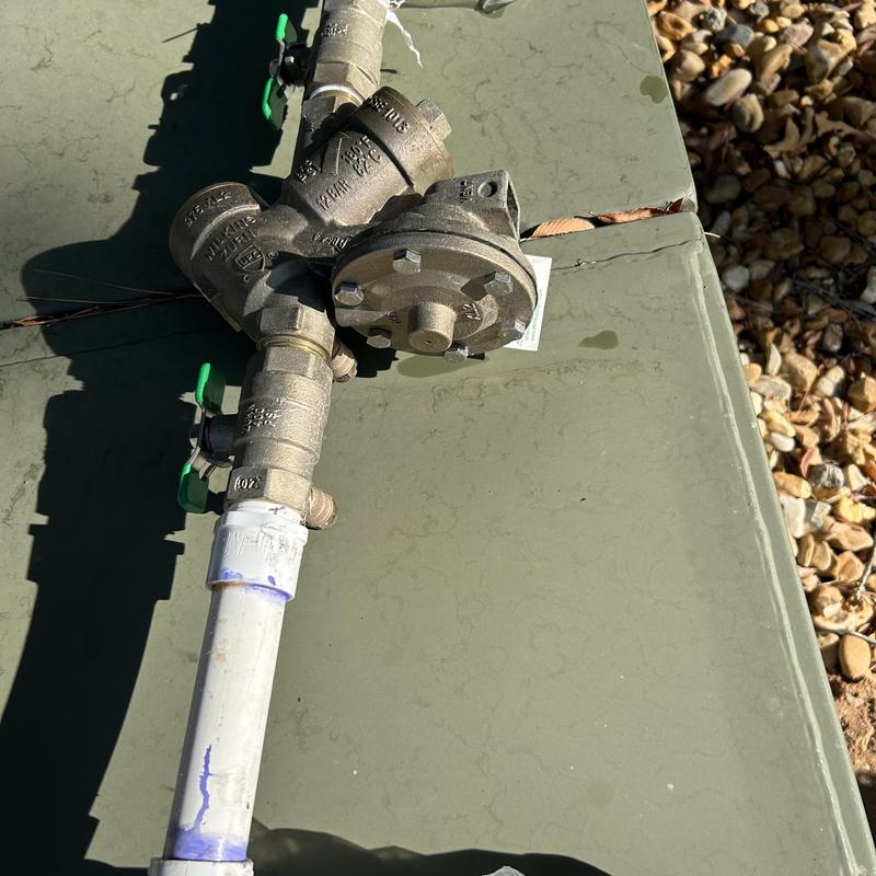 RPZ valve assembly with attached PVC piping outdoors