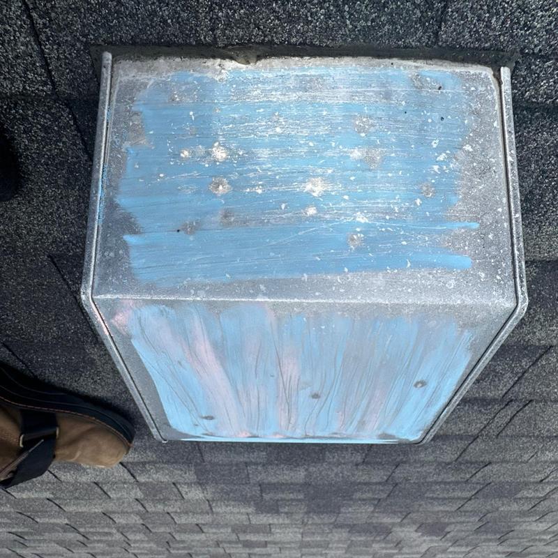 Roof vent cover on asphalt shingle roof during inspection