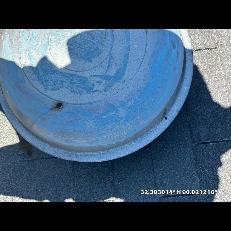 Roof vent pipe with rust and hole damage on shingles