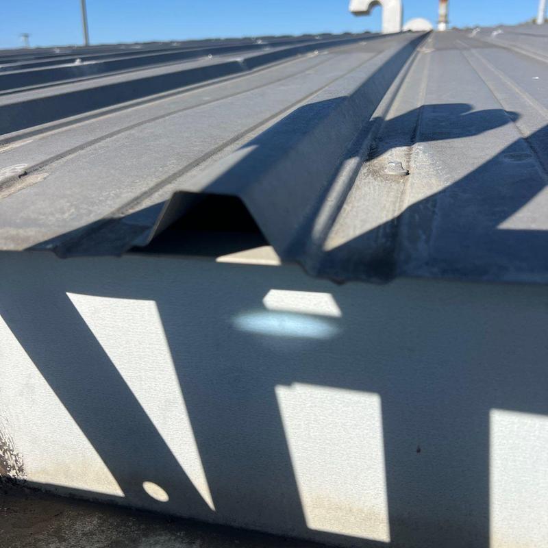 Metal commercial roof panel with storm damage inspection