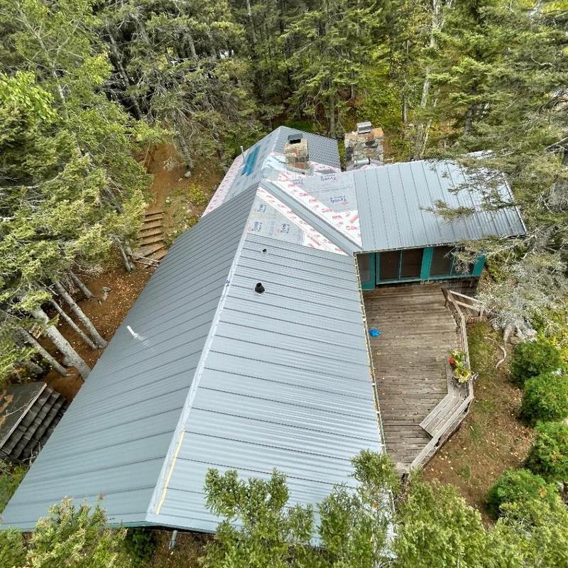 Standing seam steel roof installation with rebuilt chimney Standing seam steel roof installation with rebuilt chimney