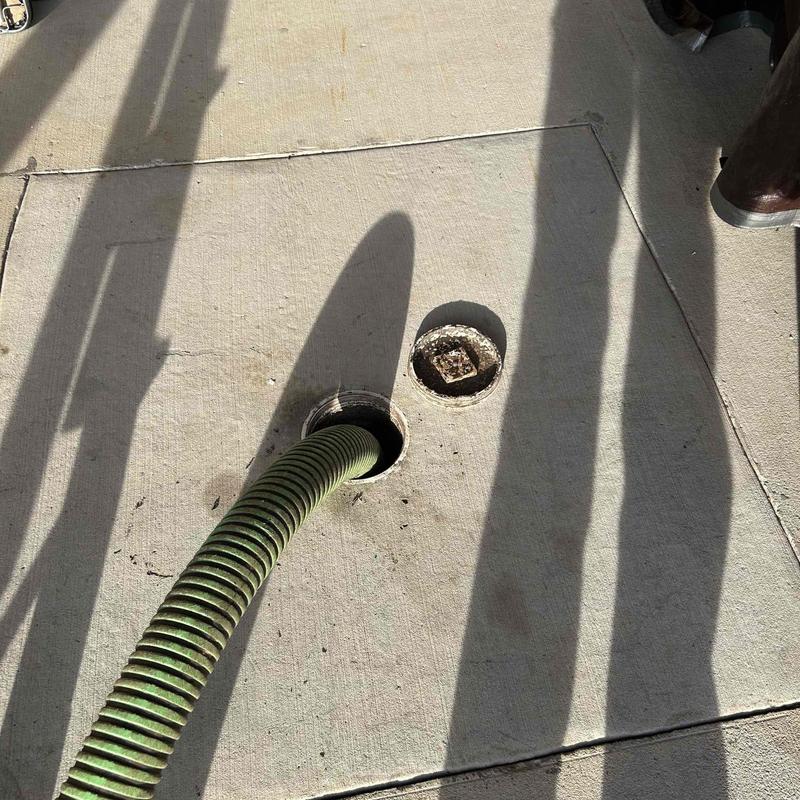 Septic tank riser with vacuum hose inserted