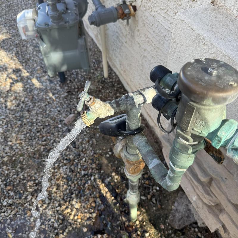 Leaking outdoor hose bib and water meter setup outdoors