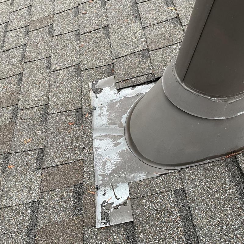 Exhaust vent flashing with secure fasteners on shingle roof