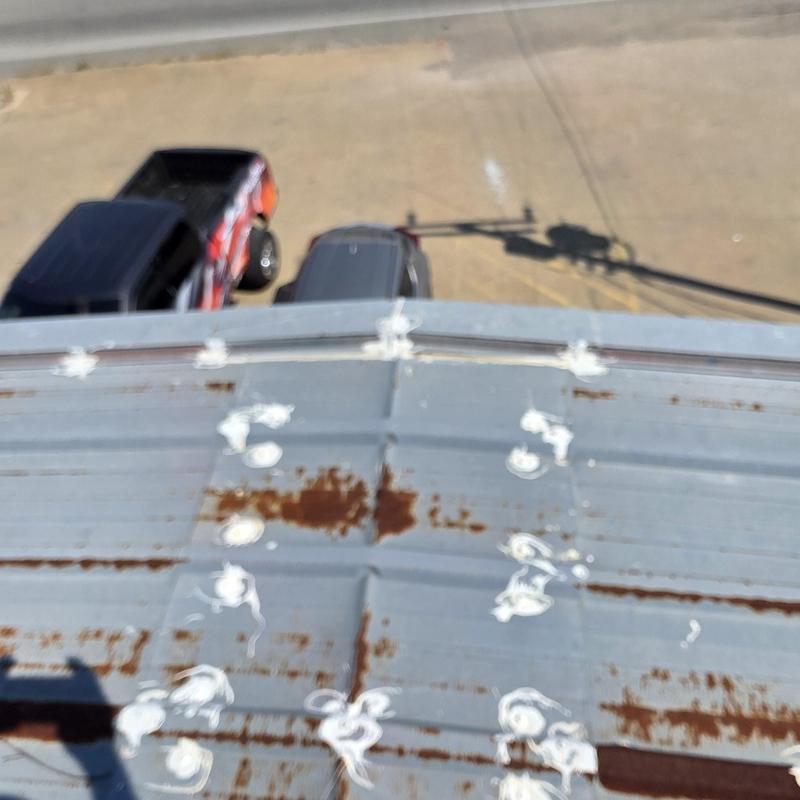 Metal roof hail damage with rust spots and sealant marks Metal roof hail damage with rust spots and sealant marks