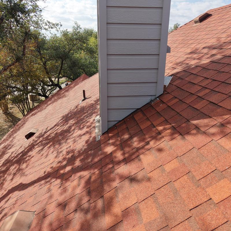 Terra cotta asphalt shingle roof with chimney flashing