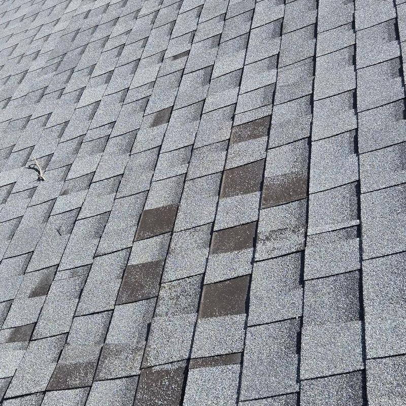 Asphalt roofing shingles with storm damage discoloration Asphalt roofing shingles with storm damage discoloration