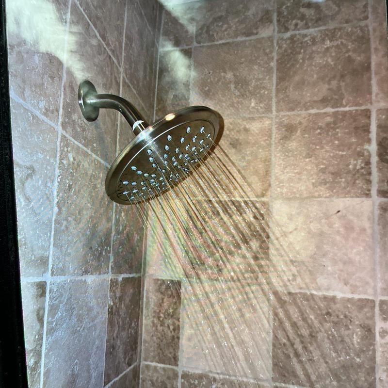 Shower head with water flow in tiled shower wall