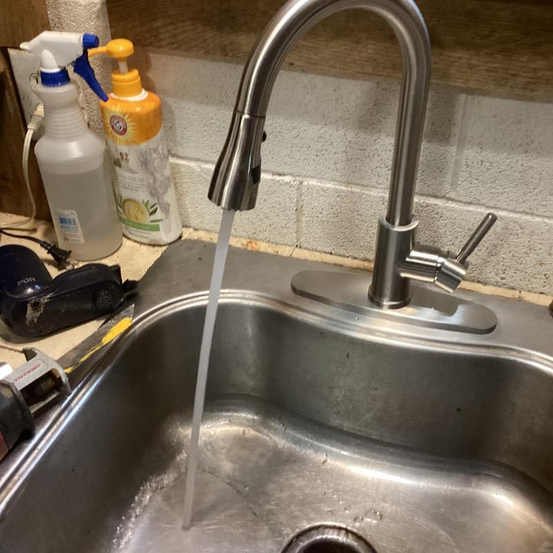Kitchen sink faucet with running water in stainless sink