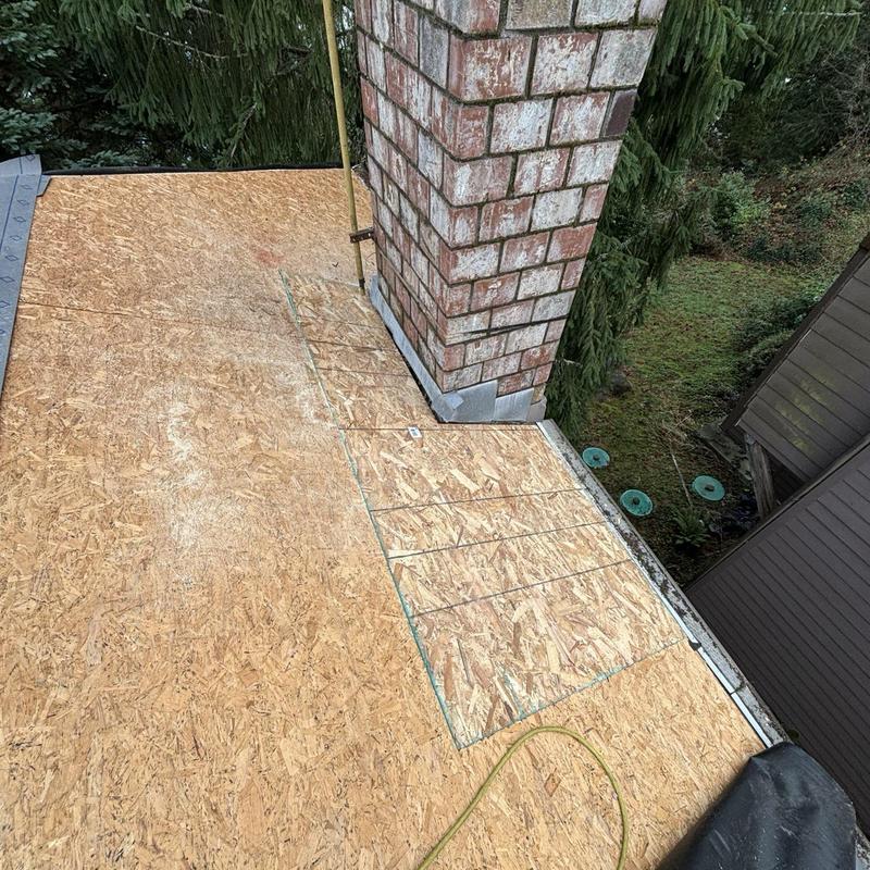 Asphalt shingle roof plywood decking near chimney installation
