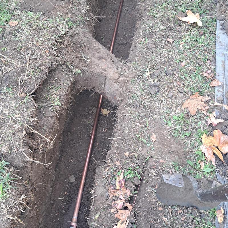 Copper water pipe trench with shovel and dirt removed Copper water pipe trench with shovel and dirt removed