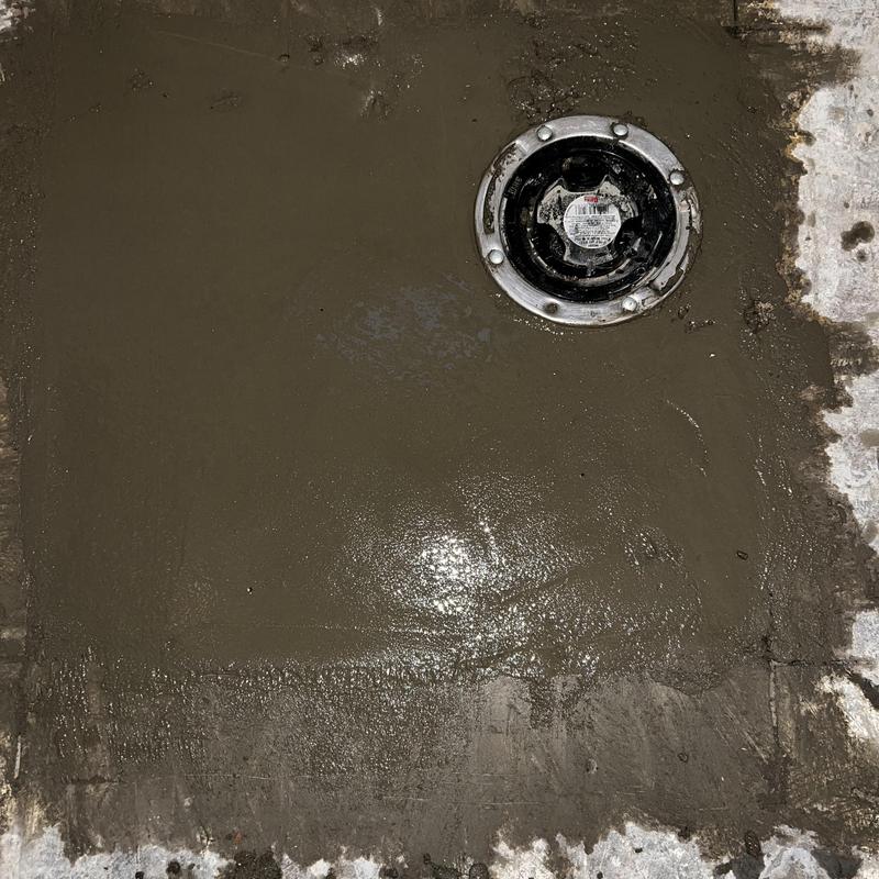 Toilet drain with fresh concrete patch