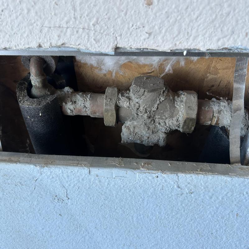 Pressure reducing valve with corroded piping inside wall cavity