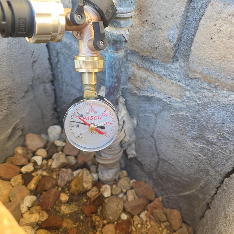 Water pressure gauge on outdoor piping system
