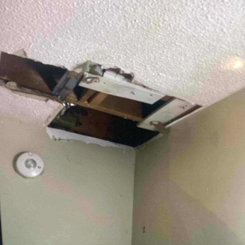 Ceiling with access hole cut for plumbing inspection