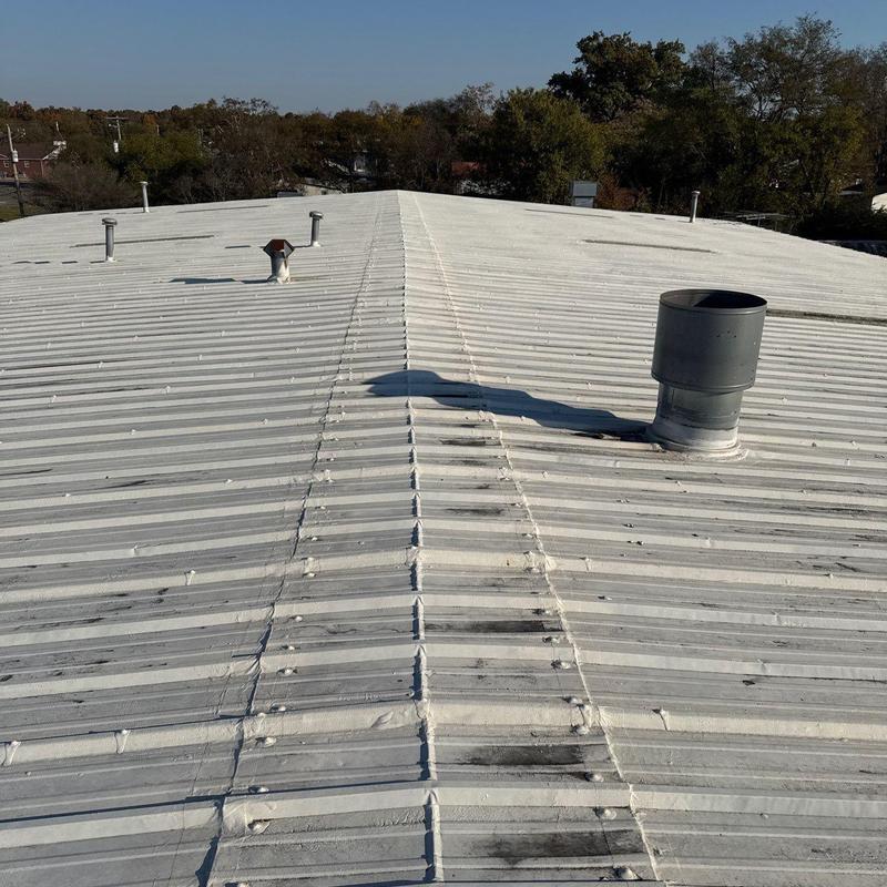 Metal roof panels with ventilation pipes on commercial building