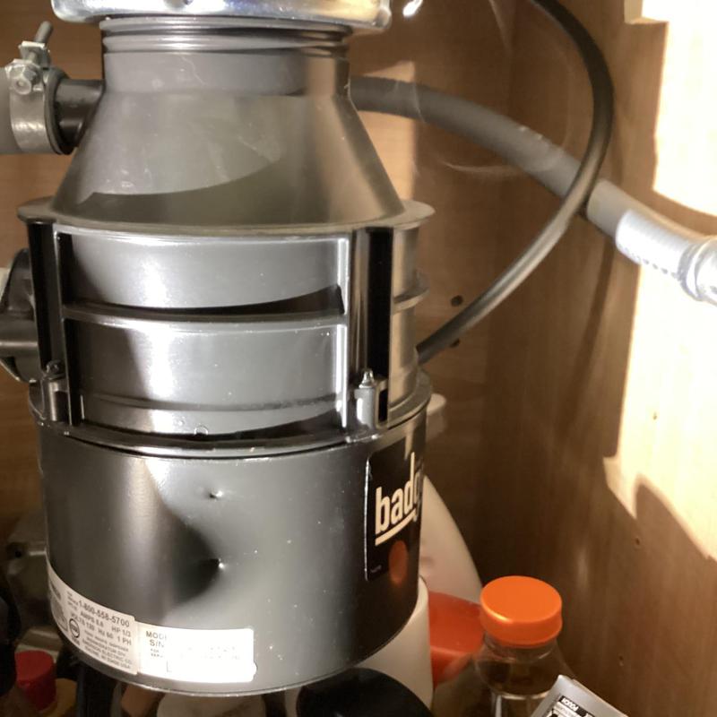 Garbage disposal unit with visible dents under sink