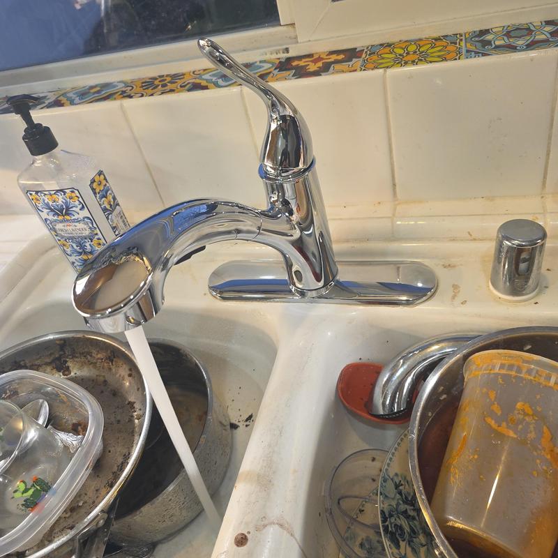 Chrome kitchen faucet with pull-out sprayer running water