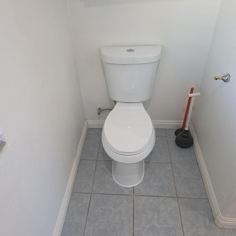 Toilet with new wax ring and sealed base in bathroom