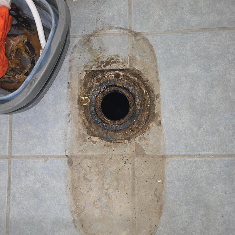 Closet flange on tiled floor with removed toilet