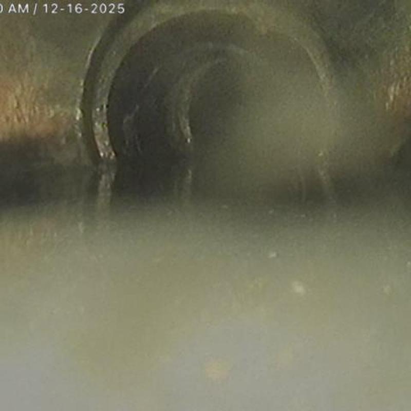 Sewer pipe interior partially blocked with debris