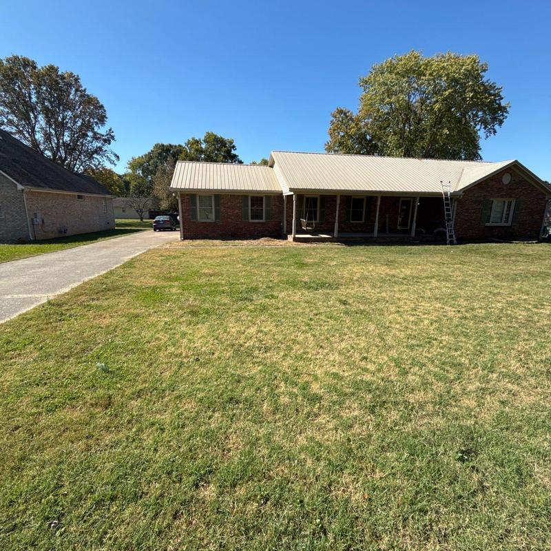 Metal roof inspection with ladder setup on house