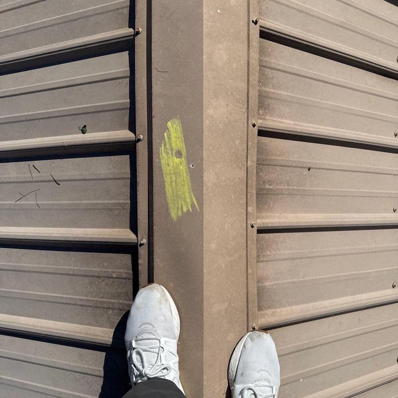 Metal roof ridge with storm damage marking in Murfreesboro