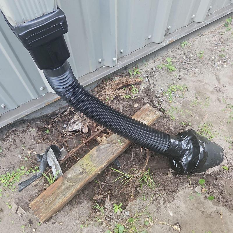 Gutter downspout extension secured with tape outdoors Gutter downspout extension secured with tape outdoors