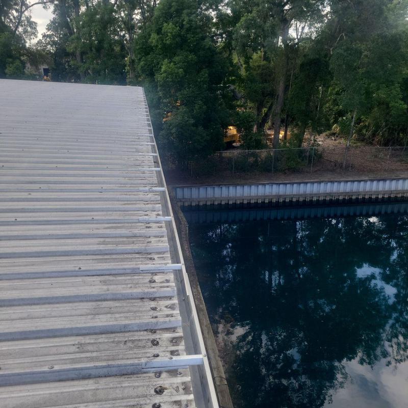 Metal roof gutter with debris cleared and repaired section Metal roof gutter with debris cleared and repaired section