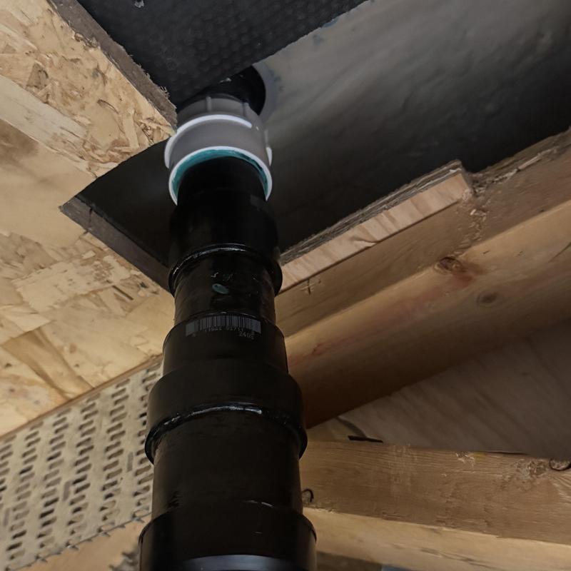 Freestanding tub drain pipe under floor joists