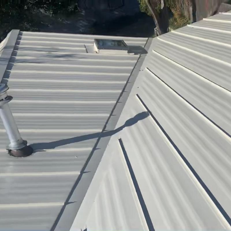 Bone white striated metal roof with skylight installed