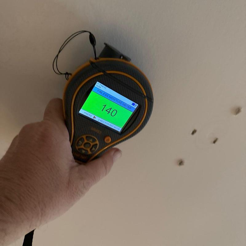 Moisture meter reading on drywall ceiling surface