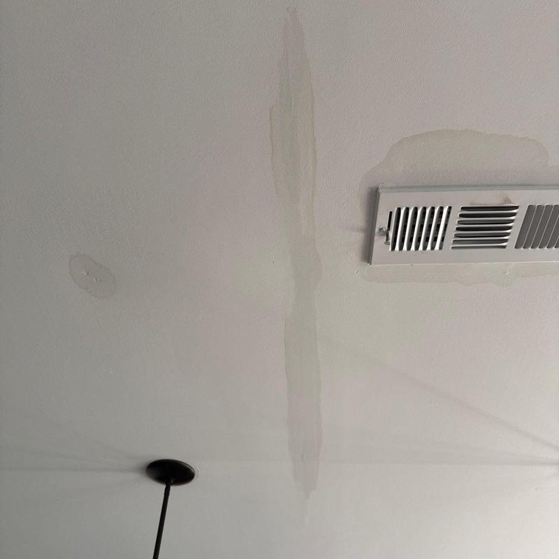 Ceiling water stains near HVAC vent and light fixture