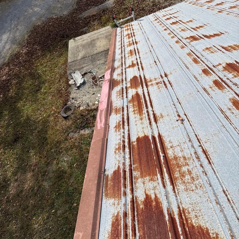 Rusty metal roof panels with visible corrosion and wear