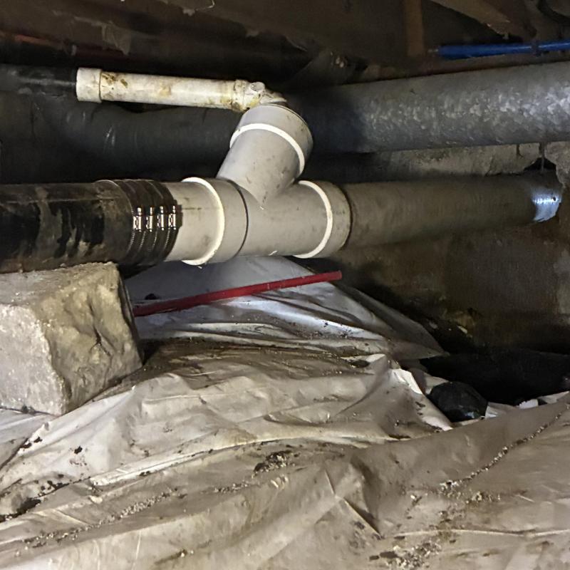 PVC drain pipe with crawlspace repair clamps installed